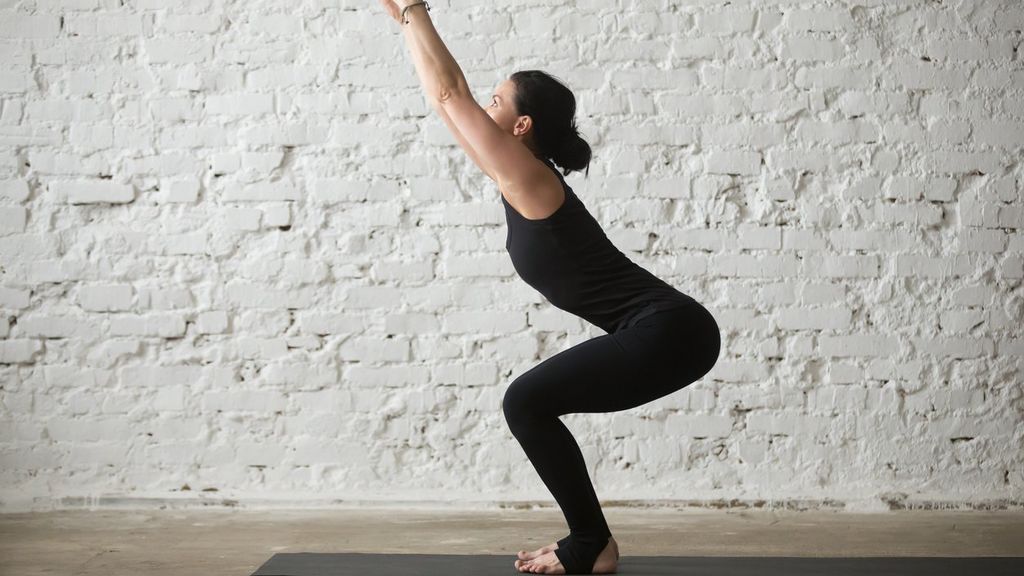 mujer realizando la postura de la silla mediante una práctica de yoga