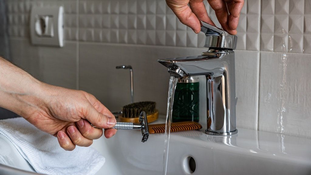 person-holding-stainless-steel-faucet-3944859