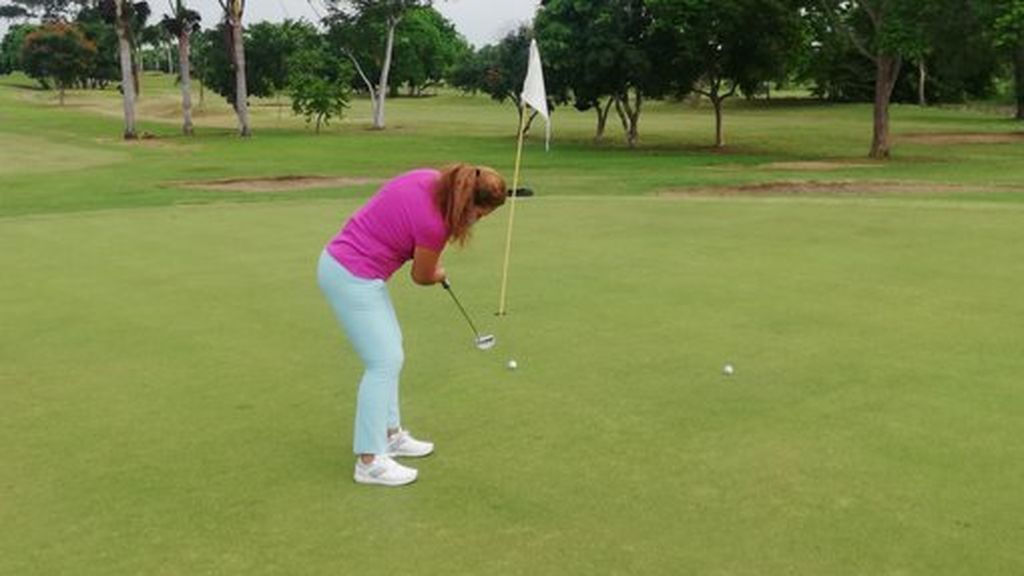 mujer realizando un putter en golf
