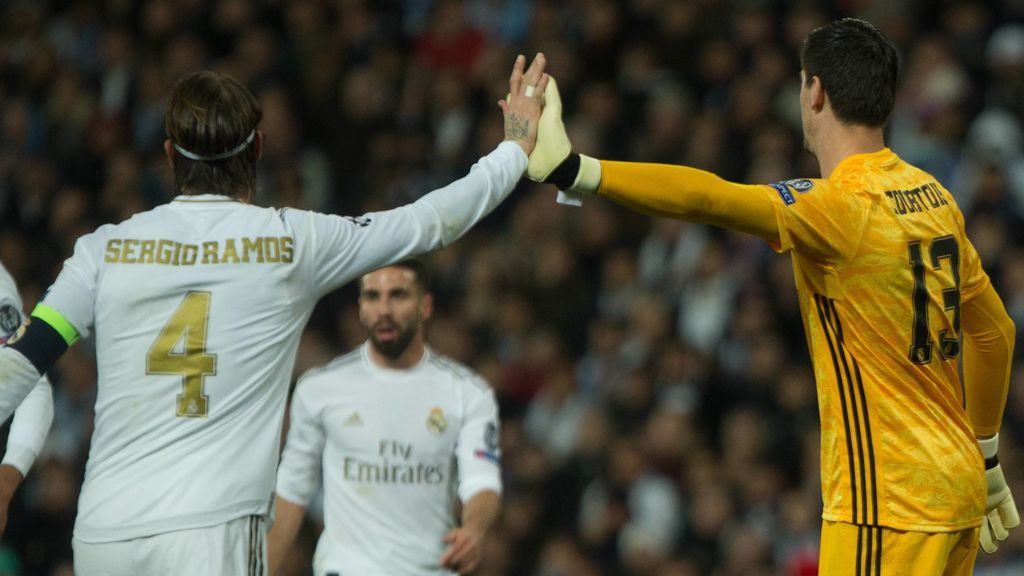 Ramos y Courtois se chocan la mano en un partido.