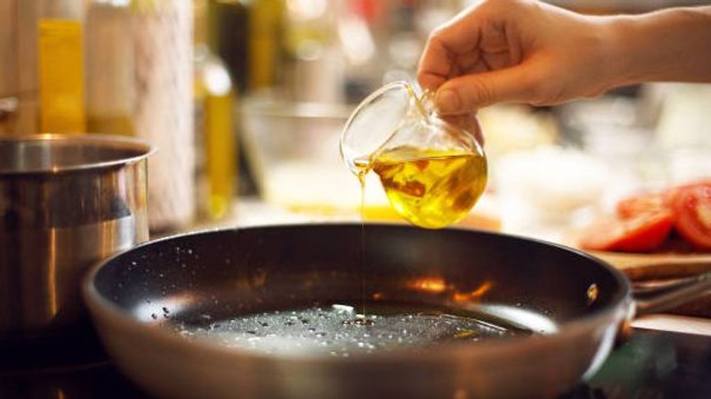 cook pours oil on a skillet