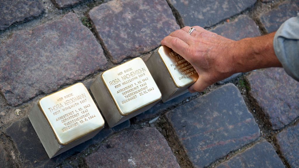 El artista Gunter Demnig pone tres Stolpersteine.