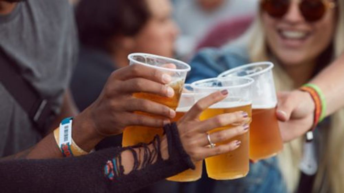Close-up uf hands toasting in beer, at festival