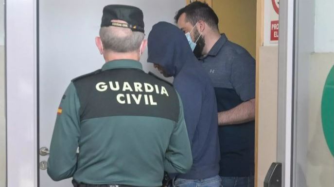 Dos agentes llevan al hombre detenido por haber agredido supuestamente a su pareja en Carballo