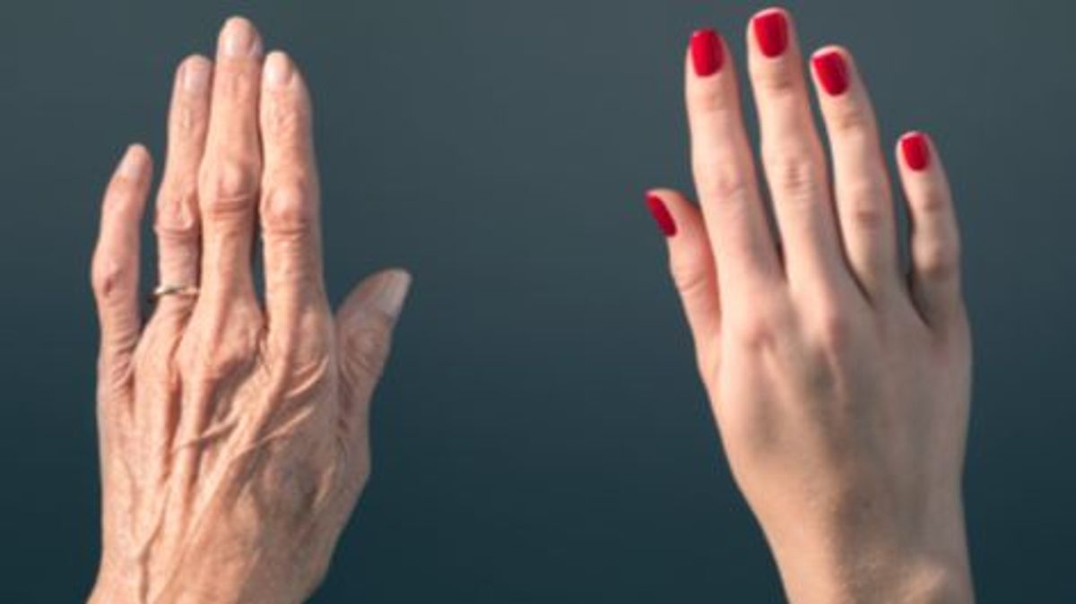 Studio photograph of elderly woman's hand beside a younger woman's hand. Studio photograph of elderly woman's hand beside a younger woman's hand.