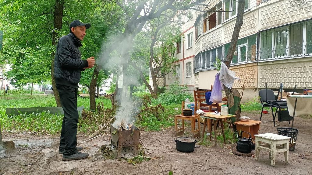Eduard, el hijo de Ludmila, preparando la comida en el patio