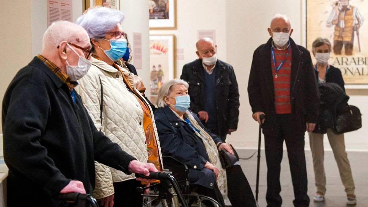 Personas mayores visitando una exposición de Berlanga