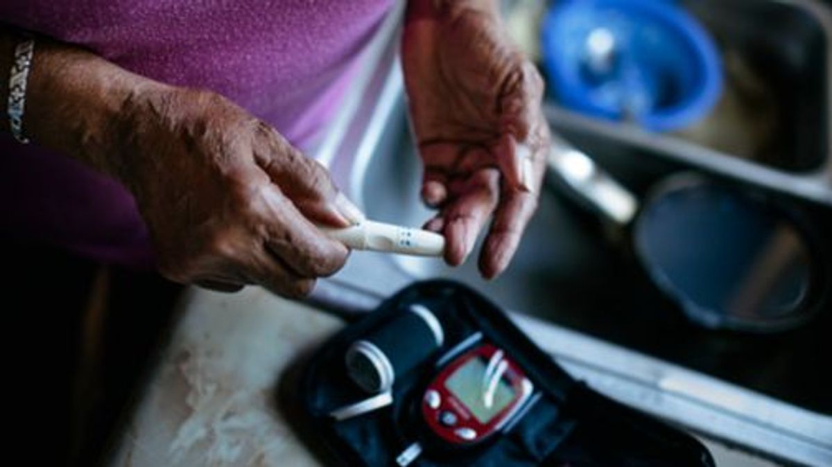 Senior woman checking blood sugar levels with a diabetes home test kit. Black middle class America family. Senior woman checking blood sugar levels with a diabetes home test kit. Black middle class America family.