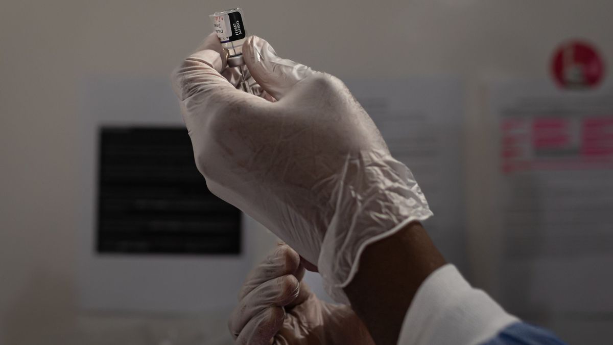 Un sanitario prepara una dosis de la vacuna del coronavirus con un vial y una aguja Un sanitario prepara una dosis de la vacuna del coronavirus con un vial y una aguja