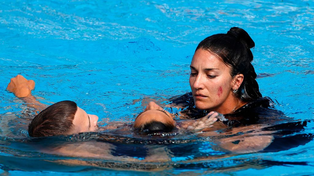 La entrenadora Andrea Fuentes sostiene a Anita Álvarez ayudada por un socorrista después de que se desmayara durante una ejecución en el Campeonato de Budapest