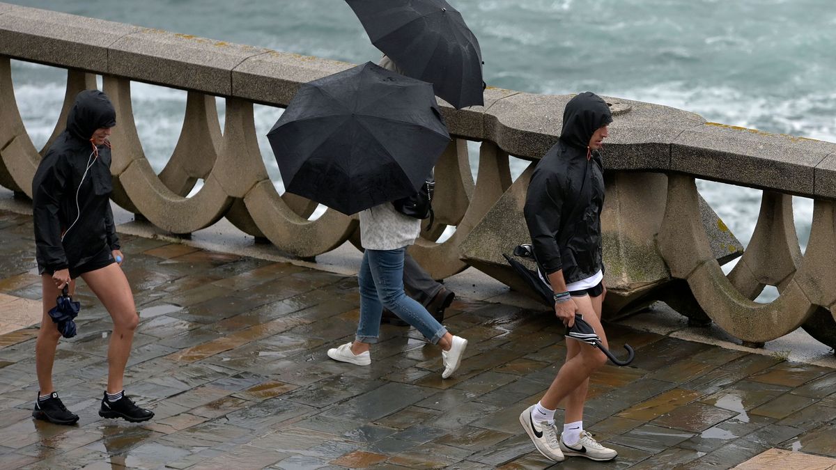Varias personas con paraguas caminan por el Paseo Marítimo de La Coruña, a 19 de junio de 2022, en A Coruña. Varias personas con paraguas caminan por el Paseo Marítimo de La Coruña, a 19 de junio de 2022, en A Coruña.