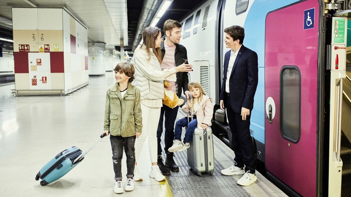 Pasajeros junto a un tren de Ouigo Pasajeros junto a un tren de Ouigo