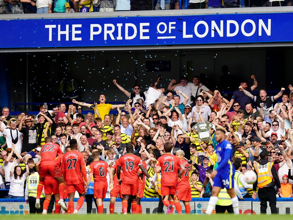 Aficionados del Watford celebran un gol de equipo ante el Chelsea en Stamford Bridge en la Premier Legaue 2021-2022.