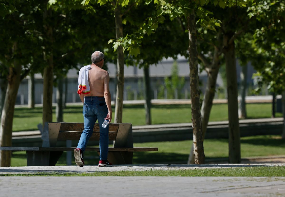 Un hombre camina sin camiseta el día en que España ha comenzado a sufrir un 'importante' episodio cálido con temperaturas de pleno verano, a 17 de mayo de 2022, en Madrid (España). Algunas zonas de la península rozarán los 40 grados centígrados y noches t