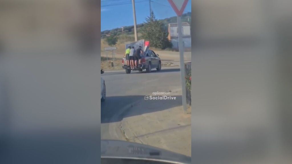 Inexplicable ocurrencia en la carretera: subidos a la parte trasera de un coche para sujetar la mercancía (Junio 2022)