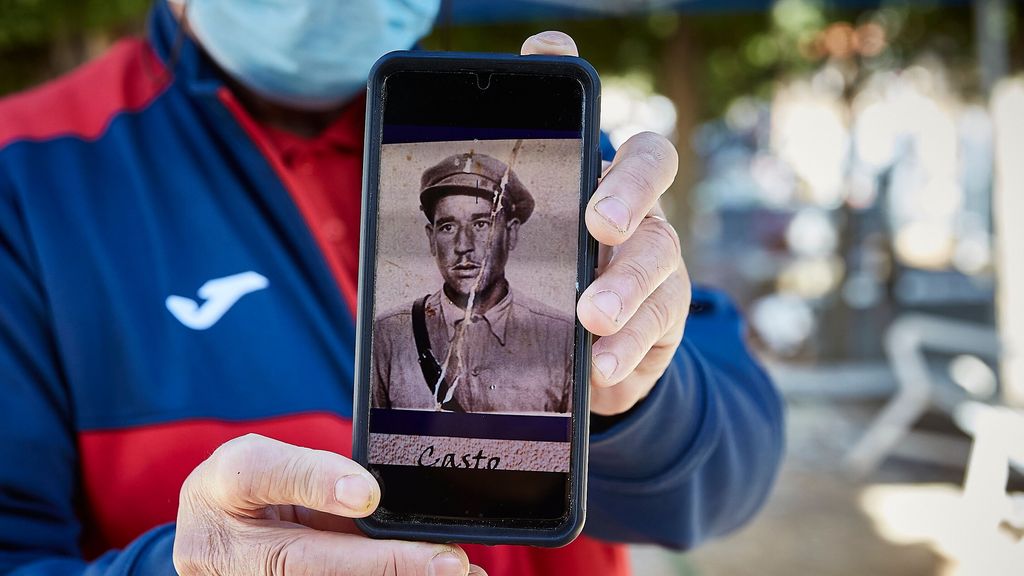 Un hombre muestra una fotografía de un familiar durante la exhumación de víctimas de la dictadura en el cementerio de Guadalajara