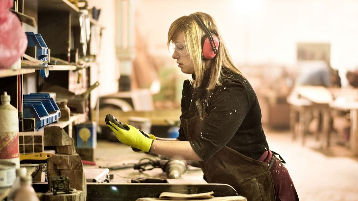 Una mujer trabajando en un taller. Una mujer trabajando en un taller.