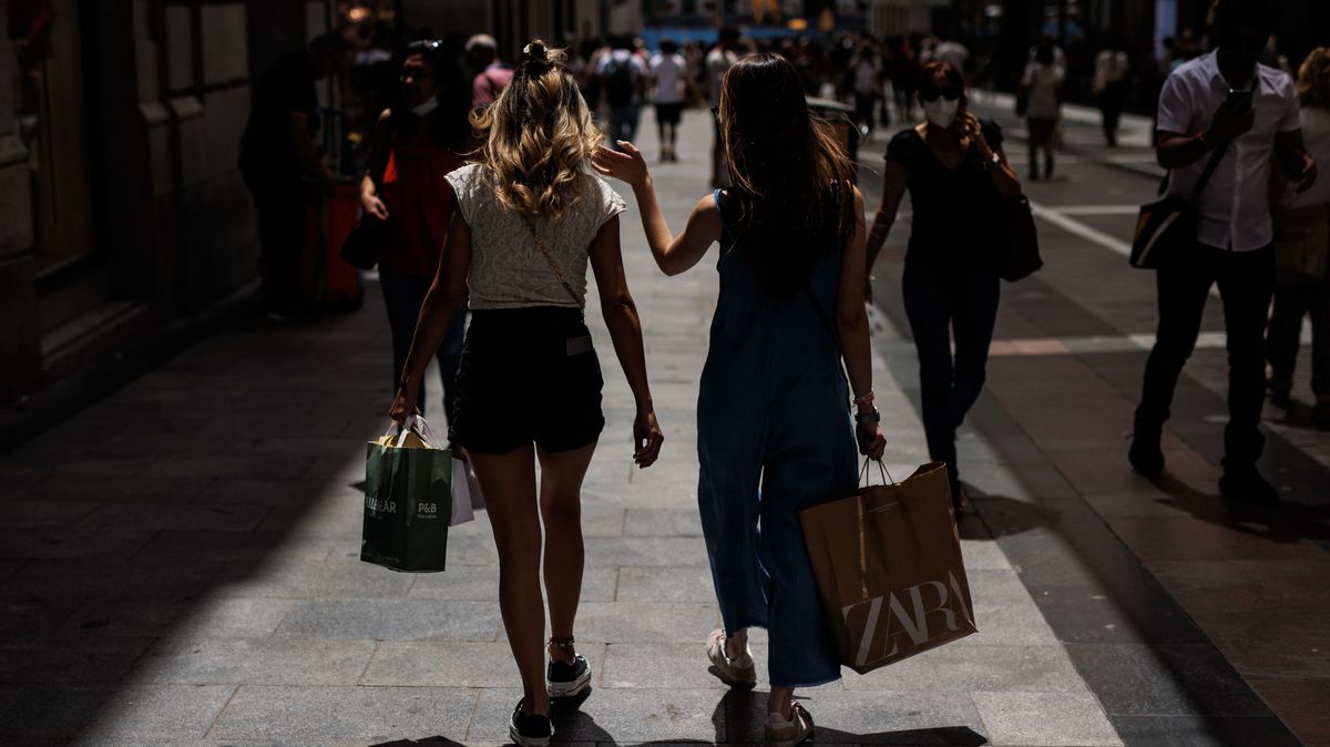 Dos mujeres pasean con bolsas por la calle Preciados, a 21 de junio de 2022, en Madrid (España).