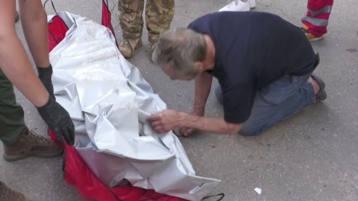 Un hombre llora sin consuelo junto al cadáver de su esposa, muerta en un ataque de Rusia en Járkov