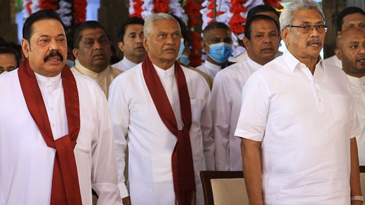 El primer ministro de Sri Lanka Mahinda Rajapaksa, su hermano mayor Chamal Rajapaksa y su hermano menor, el presidente Gotabaya Rajapaksa cantan el himno nacional de Sri Lanka durante un evento para el juramento de los nuevos ministros del gabinete en el histórico Magul Maduwa