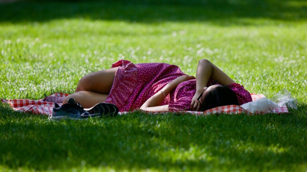 Una mujer descansando bajo una sombra.