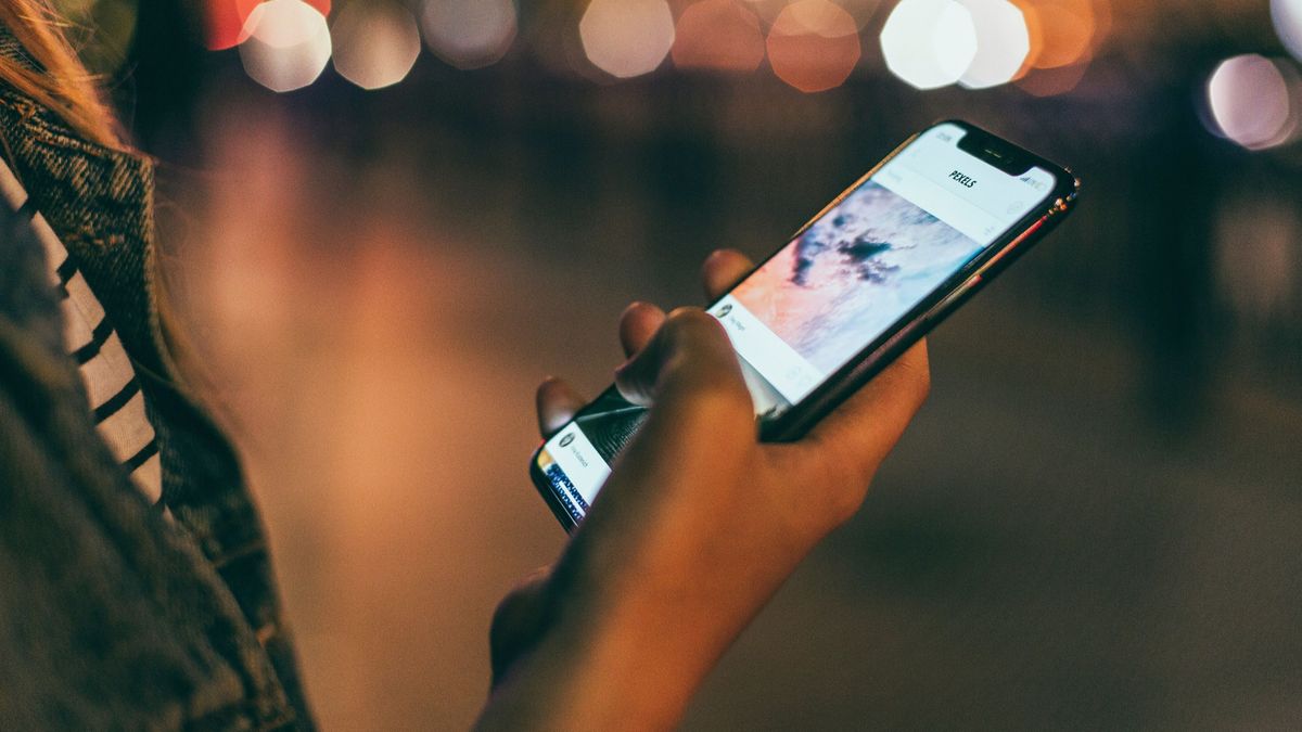 Una persona usando un teléfono móvil Una persona usando un teléfono móvil