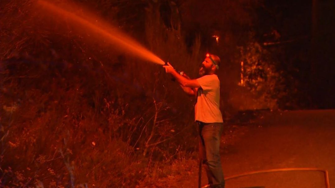 Los vecinos de Baiona, Pontevedra, manguera en mano, se lanzan a sofocar un descomunal incendio