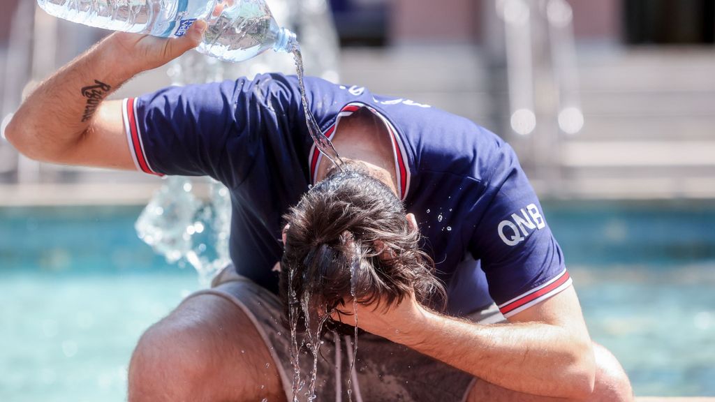 Un hombre se refresca la cabeza con agua para mitigar los efectos de la ola de calor
