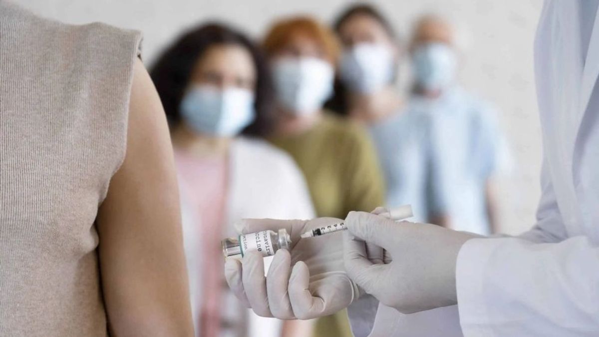 Mujeres esperan para ser vacunadas covid