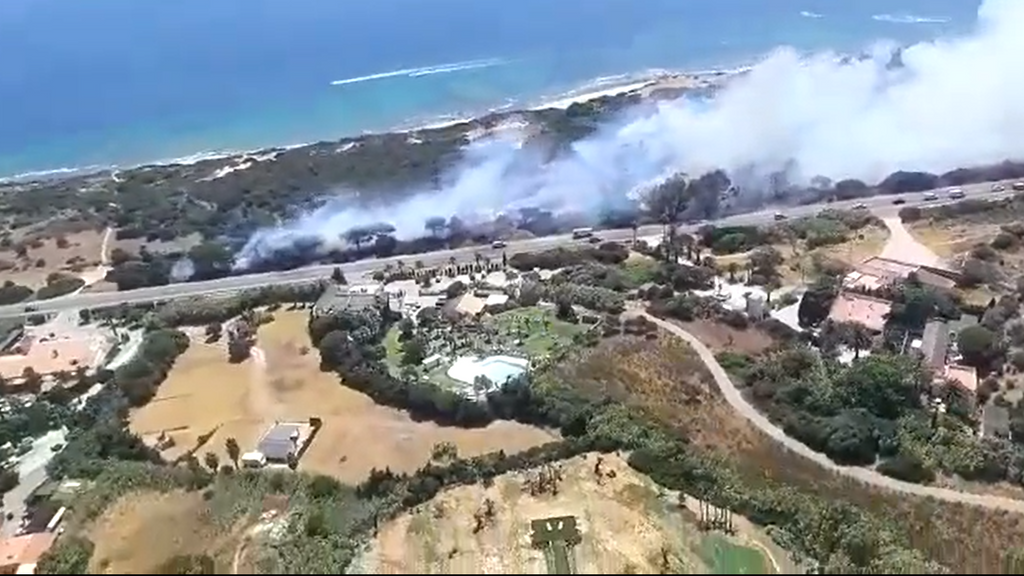 Un incendio forestal junto a la carretera sorprende a los bañistas en la playa de Valdevaqueros de Tarifa