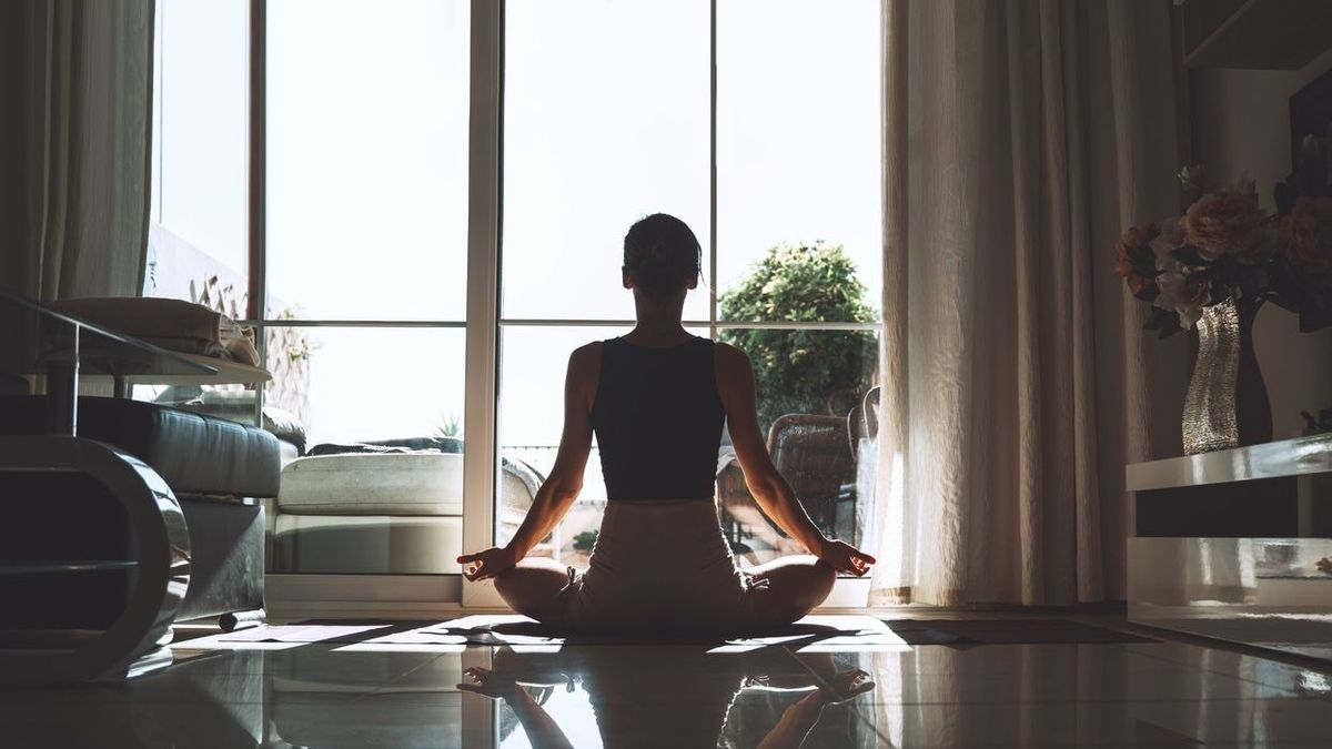 Young woman practicing yoga indoors. Beautiful girl meditating and doing the yoga poses at home. Female training for health body and mind. Concept of no stress, female happiness, freedom, relax (Young woman practicing yoga indoors. Beautiful girl medi