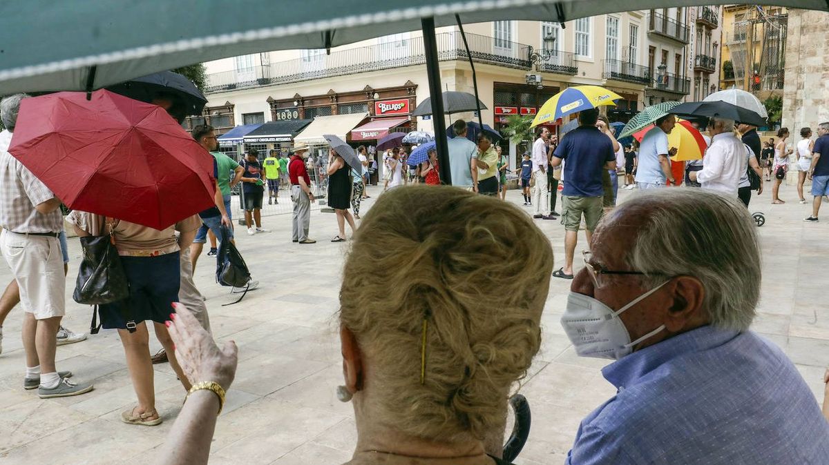 Bajo un paraguas, así protestan los vecinos de Valencia ante la falta de sombra de la nueva Plaza de la Reina