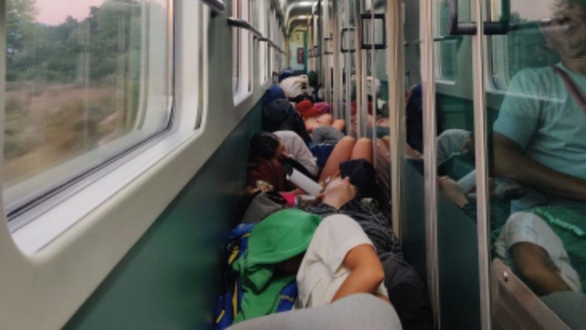 Jóvenes durmiendo amontonados en el pasillo durante el viaje en tren nocturno.