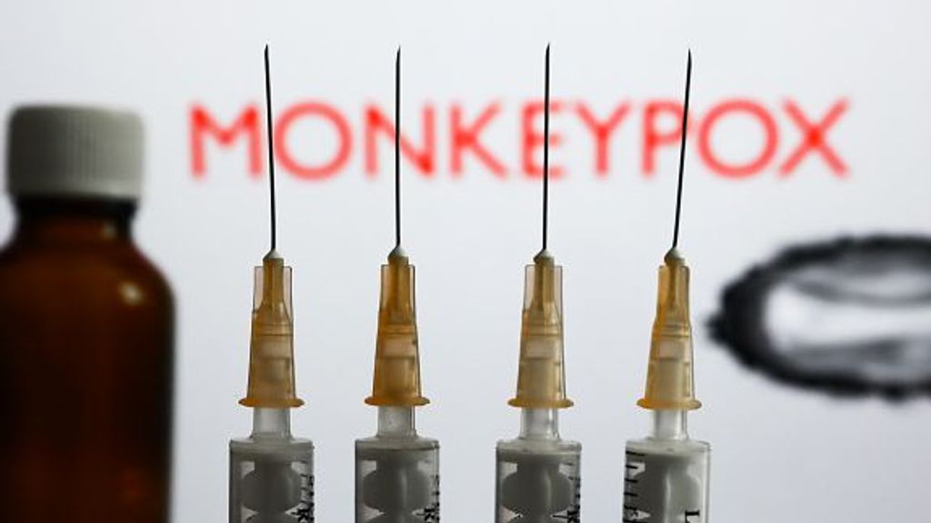 Medical syringes and a bottle are seen with 'Monkeypox' sign and monkeypox illustrative model displayed on a screen in the background in this illustration photo taken in Krakow, Poland on May 26, 2022. (Photo by Jakub Porzycki/NurPhoto via Getty Images)