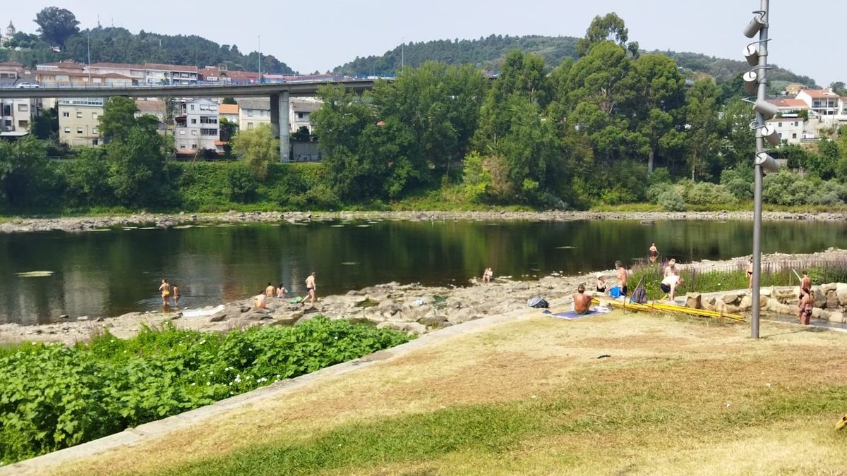 Personas refrescándose a orillas del río Miño. Personas refrescándose a orillas del río Miño.