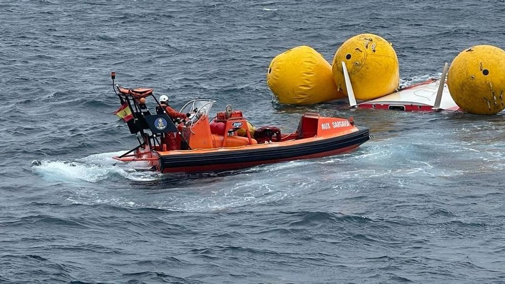 Una lancha auxiliar de Salvamento Marítimo junto al velero.