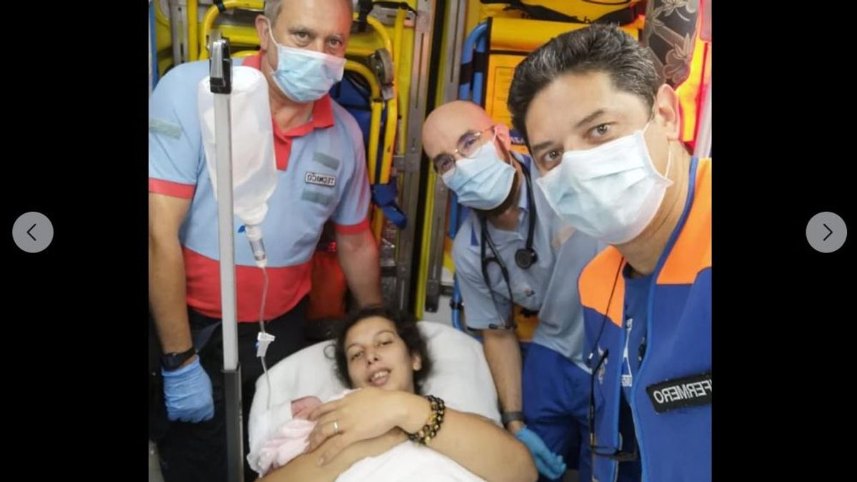 Macarena con su hija Emma en brazos rodeada del personal que la atendió en la ambulancia