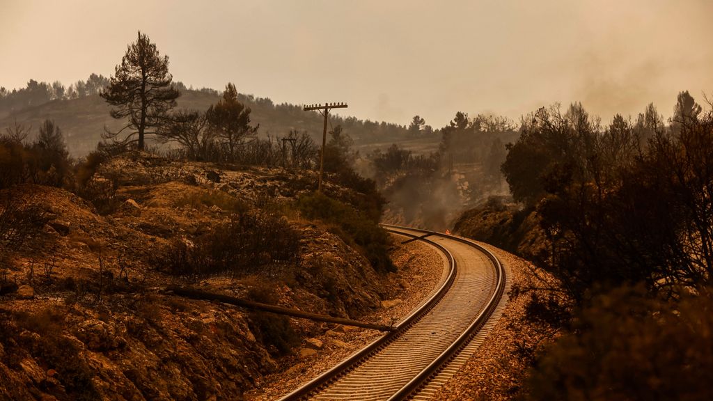 Vías del tren en Bejís, con el incendio de fondo