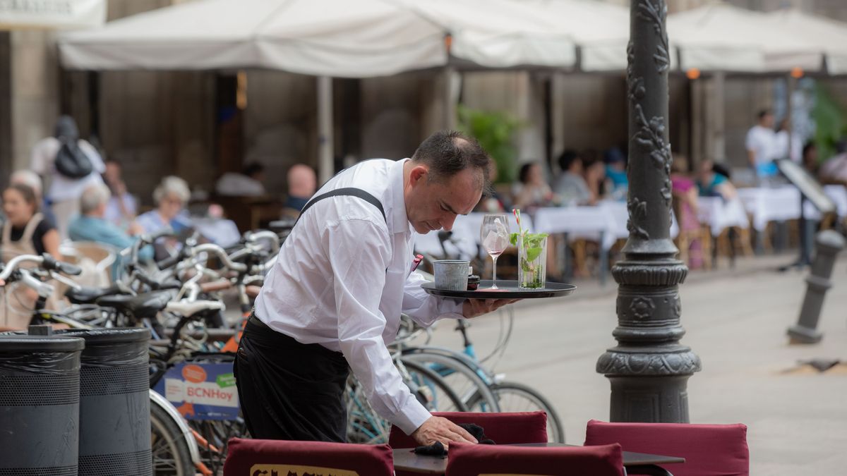 Un camarero limpia una mesa en la plaza Real de Barcelona, a 15 de junio de 2022, en Barcelona, Un camarero limpia una mesa en la plaza Real de Barcelona, a 15 de junio de 2022, en Barcelona,
