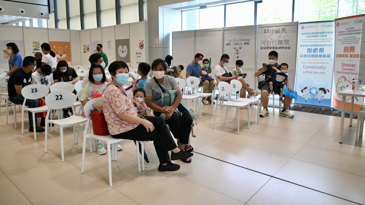 Varias personas esperan en un centro de vacunación contra el coronavirus en Hong Kong