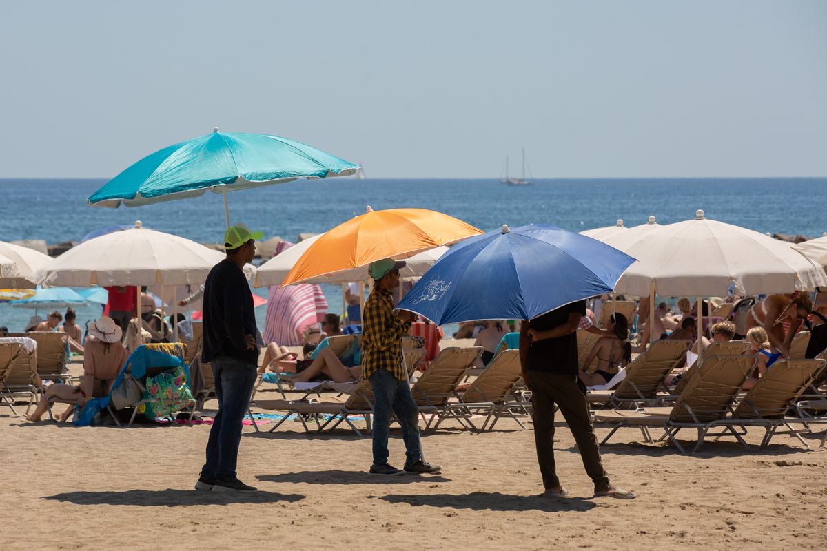 Varias personas se protegen del sol en la playa de la Barceloneta, a 13 de julio de 2022, en Barcelona, Catalunya (España). La intensa y extensa ola de calor llega hoy a su momento cumbre, aunque ese pico se mantendrá durante varios días seguidos, según l Varias personas se protegen del sol en la playa de la Barceloneta, a 13 de julio de 2022, en Barcelona, Catalunya (España). La intensa y extensa ola de calor llega hoy a su momento cumbre, aunque ese pico se mantendrá durante varios días seguidos, según l