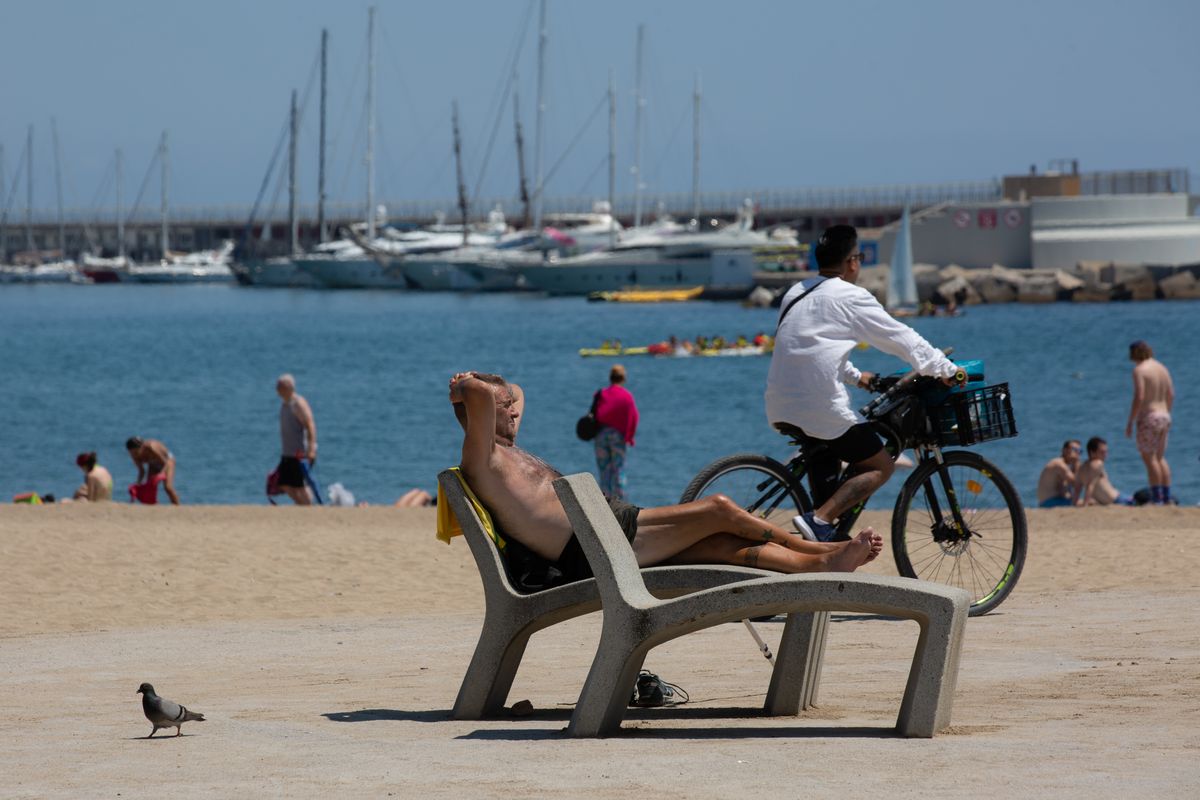 Varias personas toman el sol en la playa de la Barceloneta, a 13 de julio de 2022, en Barcelona, Catalunya (España).
