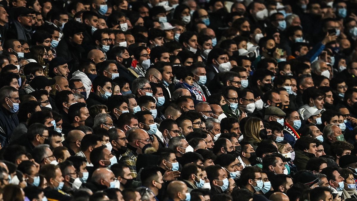 Espectadores en el estadio Santiago Bernabéu, de Madrid asisten a un partido con mascarillas