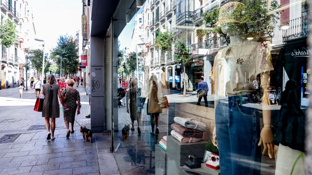 Varias personas pasan por delante de un escaparate de una tienda de ropa, a 2 de septiembre de 2022, en Madrid