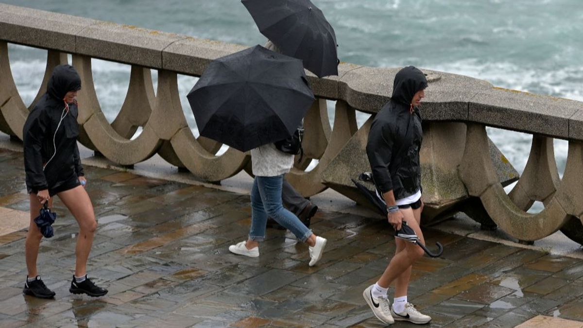 Personas caminando con paraguas por el paseo marítimo de A Coruña. Personas caminando con paraguas por el paseo marítimo de A Coruña.