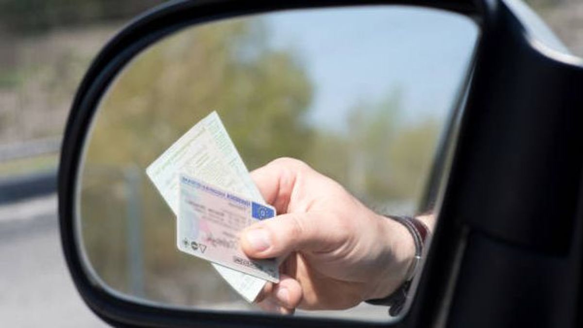 Un conductor presenta su carnet de conducir Un conductor presenta su carnet de conducir