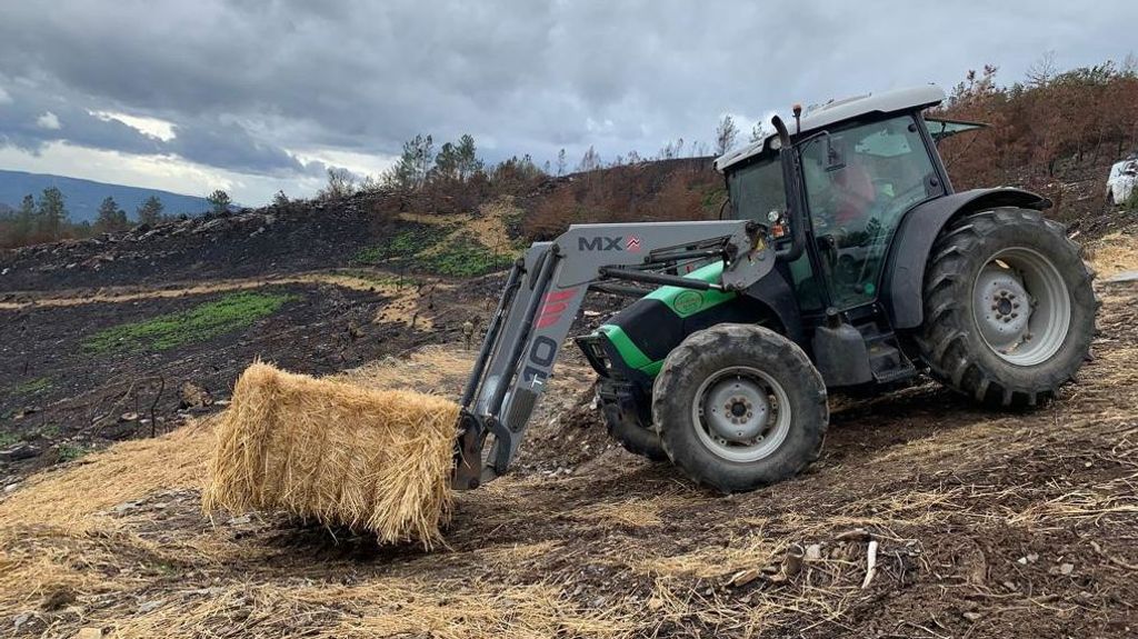 Un tractor transportando una alpaca de paja en O Courel.