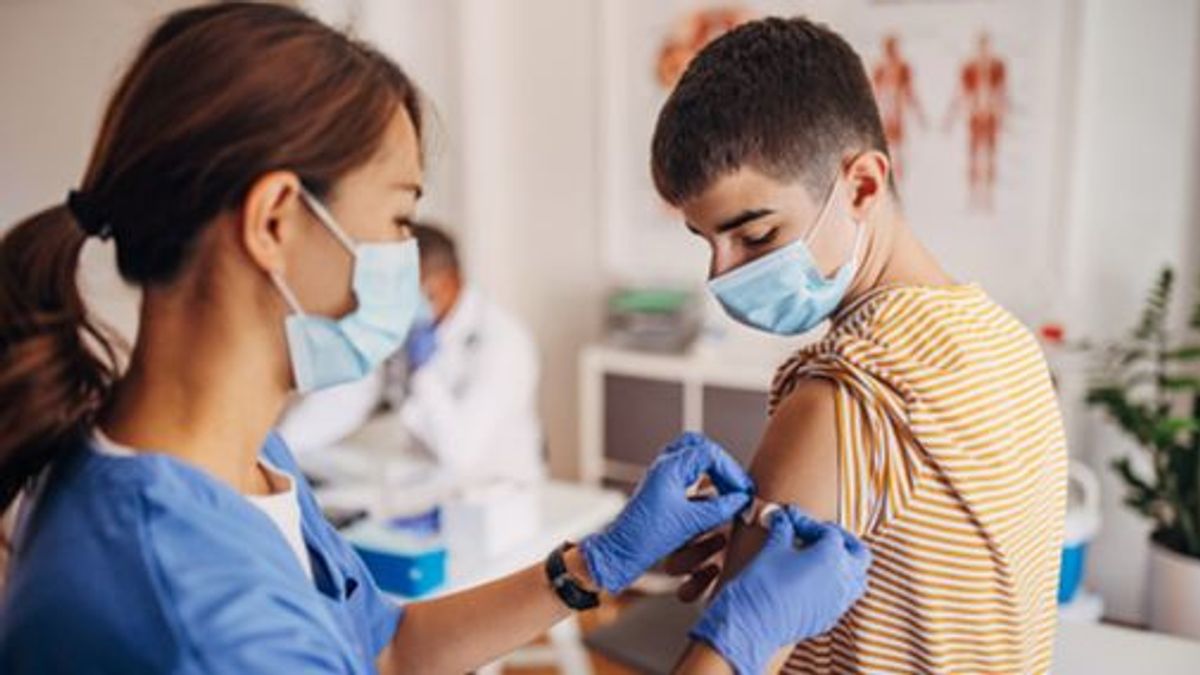 Nurse putting band aid on patient's arm after covid-19 vaccination Nurse putting band aid on patient's arm after covid-19 vaccination