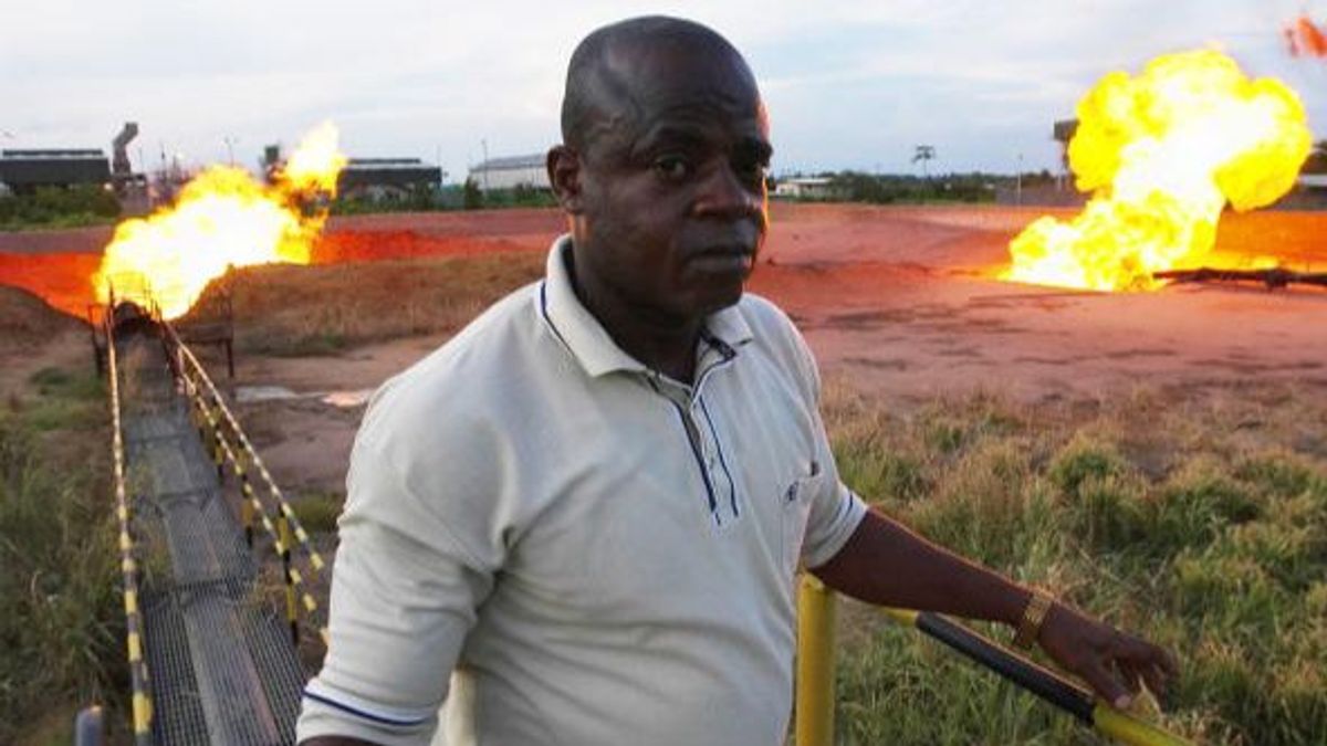 Un guardia de seguridad observa cómo se quema el gas asociado producido en los pozos de petróleo cerca de Port Harcourt, Nigeria