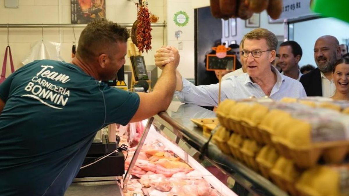 El presidente del PP, Alberto Núñez Feijóo, saluda a un comerciante en un mercado de Palma de Mallorca